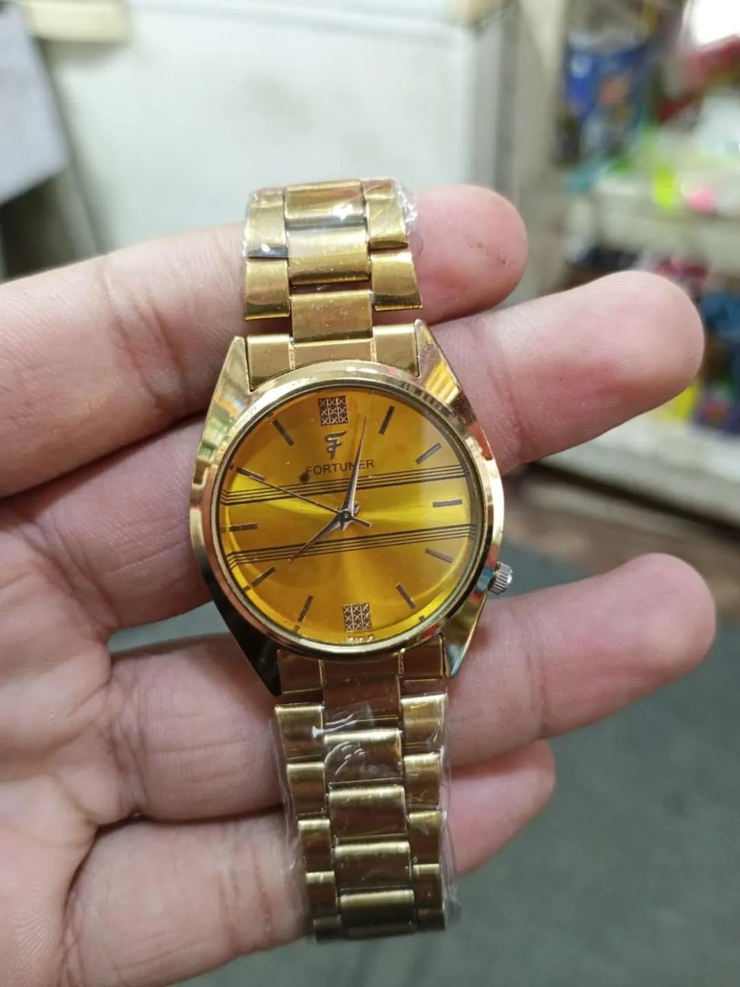 Gold Analog Wristwatch with Striped Dial & F Logo